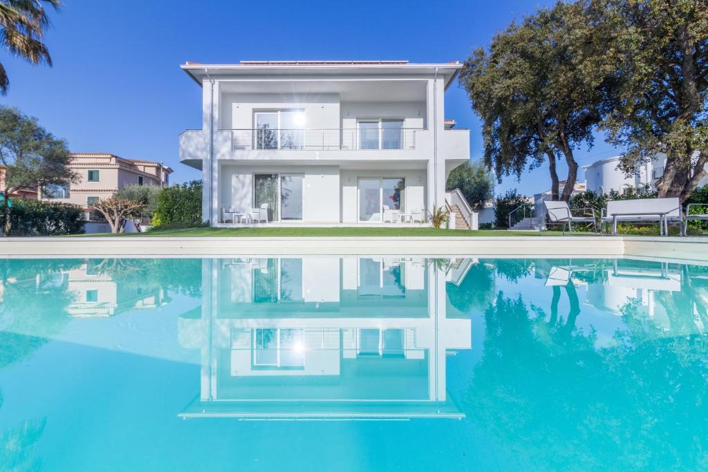 uma casa é refletida na água de uma piscina em Villa Mary em Olbia