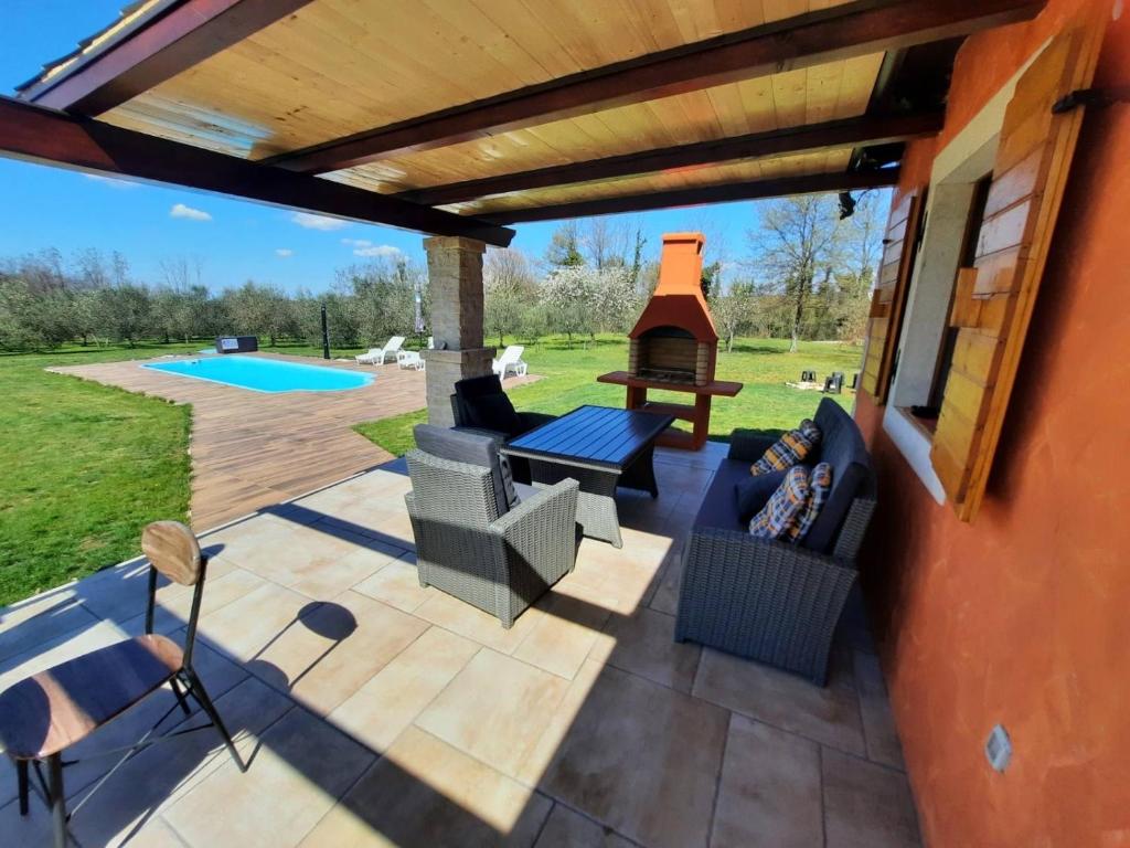 a patio with a grill and a table and chairs at House in nature in Tinjan