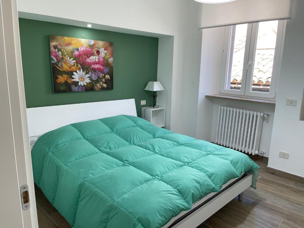 una camera con un letto con una parete verde di Dimora dei Falisci a Montefiascone