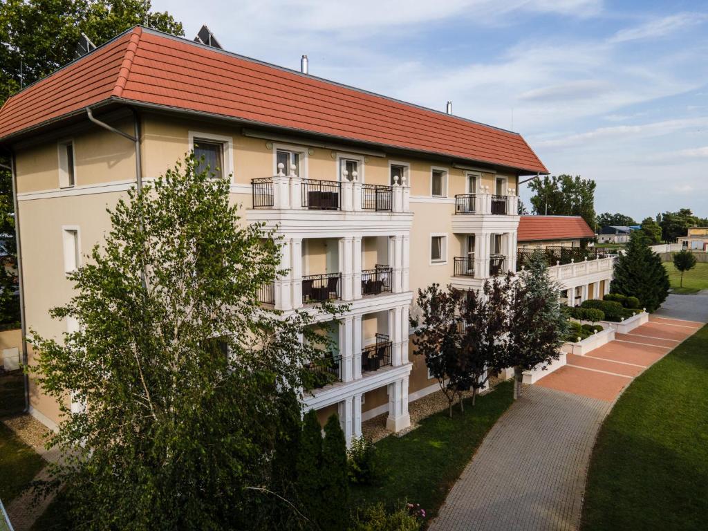 un gran edificio blanco con techo rojo en Arcanum Hotel, en Békéscsaba