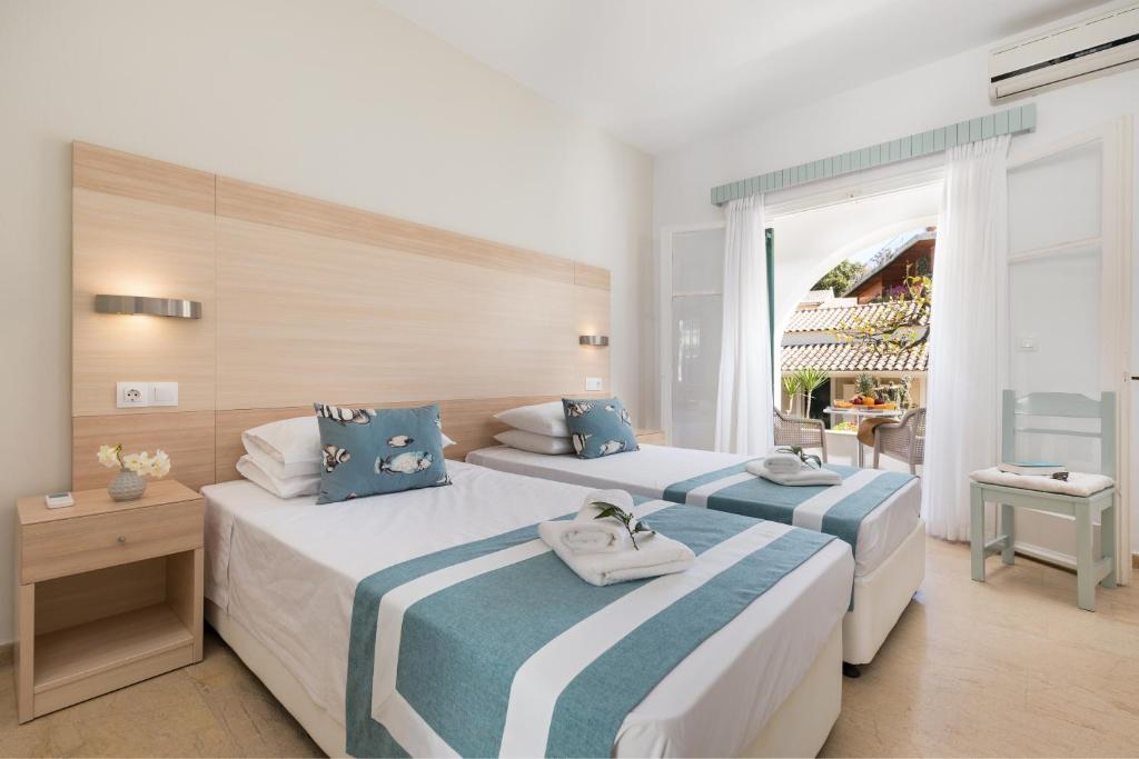 A bed or beds in a room at Iliada Beach Hotel
