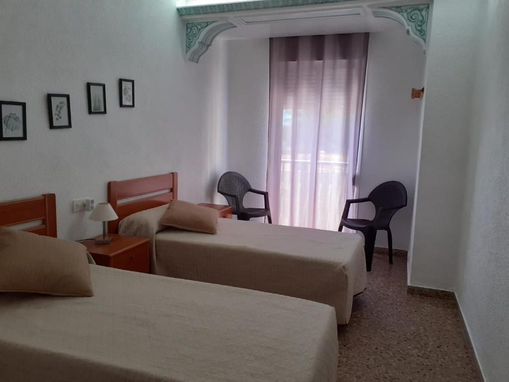 a hotel room with two beds and a window at Apartamento a 10 metros del mar in Cullera