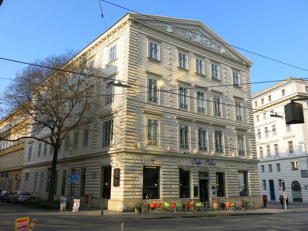 ein großes weißes Gebäude an der Ecke einer Straße in der Unterkunft aeki CITY in Wien