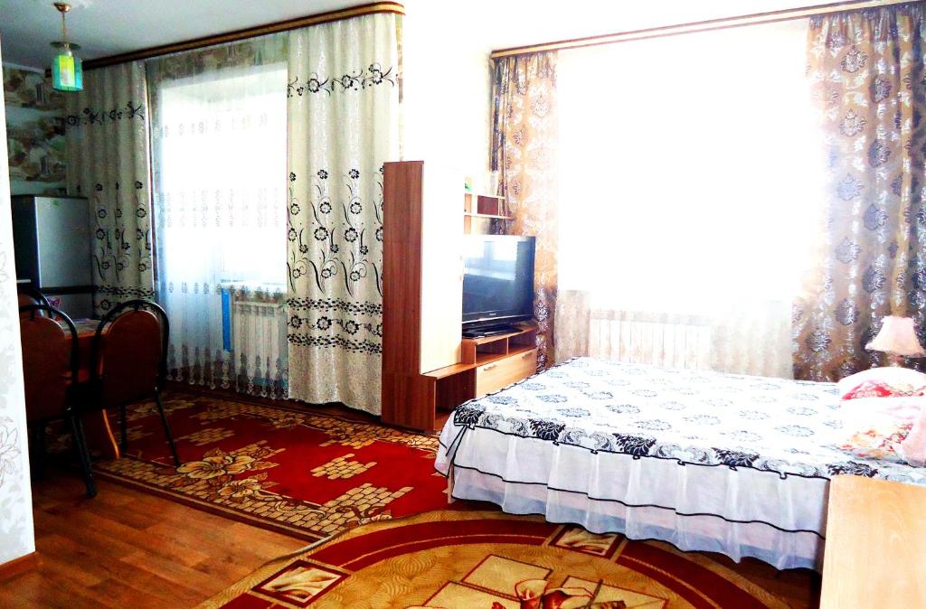 1 dormitorio con 1 cama y TV en Apartment 2Pillows Bogomyagkova 11fl, en Chita