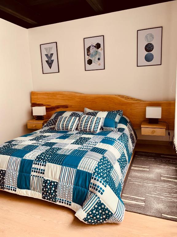 a bedroom with a bed with a blue and white blanket at Apartamento zona colonial lindísimo 101 in Zipaquirá