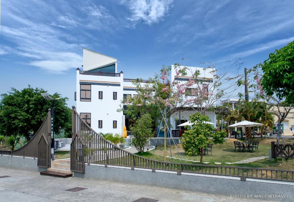 un edificio blanco con una valla delante en 極の宿 eXtreme, en Xiaoliuqiu