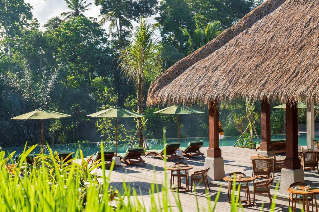 a resort with chairs and tables and umbrellas at Adiwana Suweta in Ubud