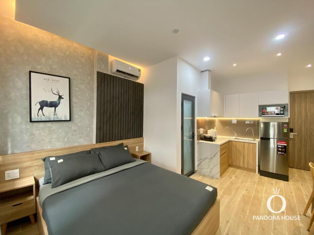 1 Schlafzimmer mit einem blauen Bett und einer Küche in der Unterkunft PANDORA HOUSE in Ho-Chi-Minh-Stadt
