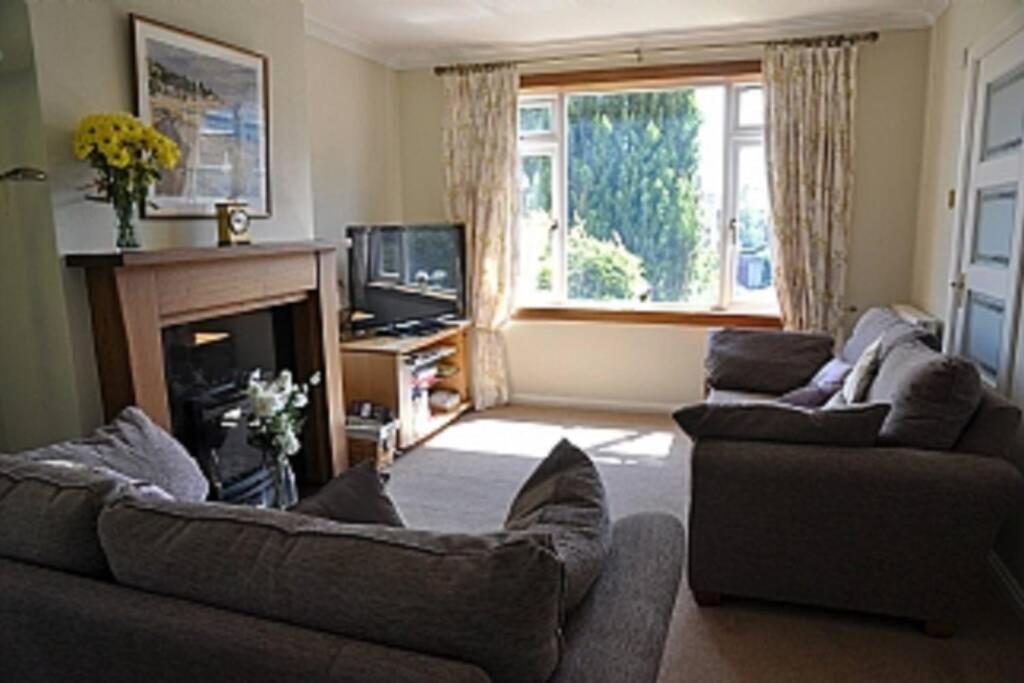 sala de estar con 2 sofás y chimenea en Sunny House with views to Edinburgh Skyline en Edimburgo