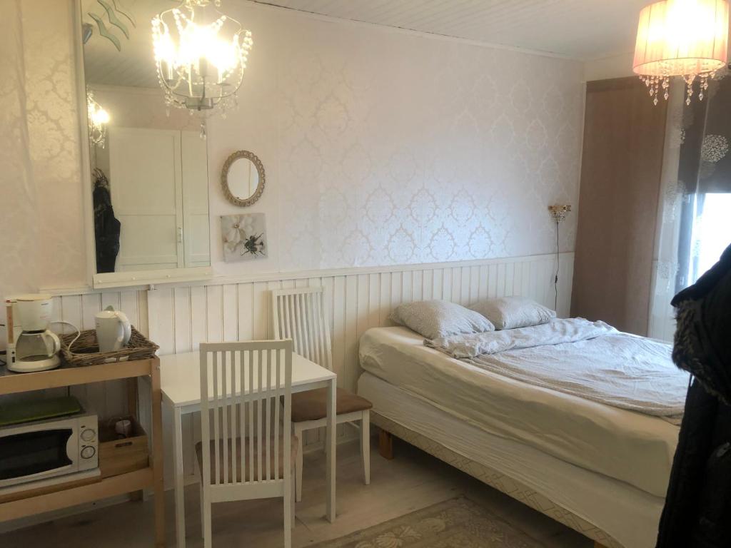 a small bedroom with a bed and a table at Puutaloasunto 1.8 km Turun aurajoelta in Turku