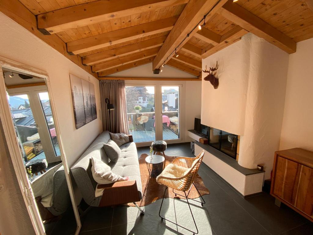 ein Wohnzimmer mit einem Sofa und einem Tisch in der Unterkunft Mira Piz Signina - Ferienwohnung für max. 4 Personen in Laax