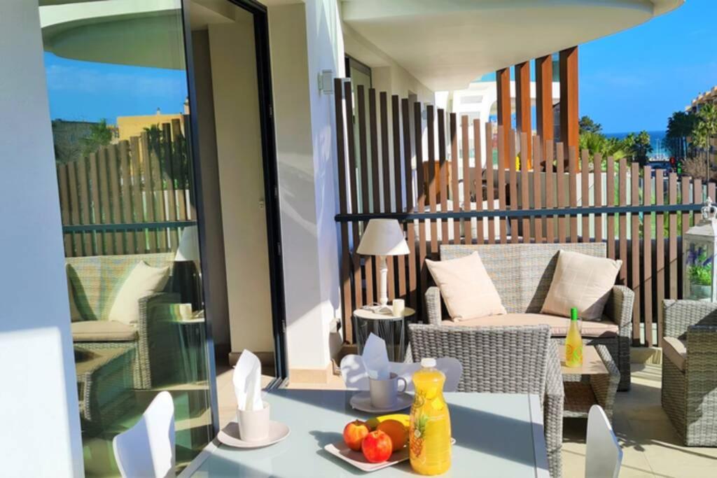 - un balcon avec un canapé et une table avec des fruits dans l'établissement LUJOSO APARTAMENTO NUEVO PLAYA CENTRO, à Estepona