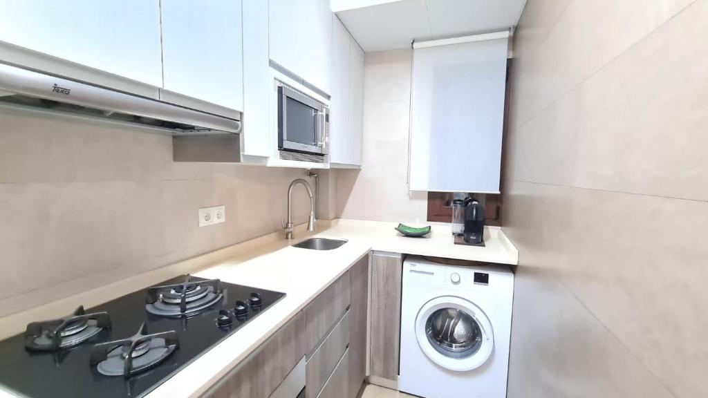 kuchnia z kuchenką i pralką w obiekcie Sunny Seaside Escape in Aguadulce w mieście Aguadulce
