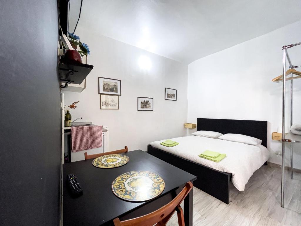 カターニアにあるLittle Sicilyのベッド、テーブル、椅子が備わる小さな客室です。