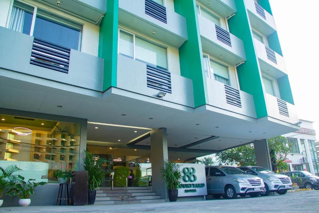 a building with cars parked in front of it at 88 Courtyard Hotel in Manila