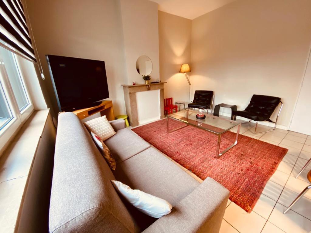 uma sala de estar com um sofá e uma televisão de ecrã plano em Fenêtre sur le Standard de Liège em Ougrée