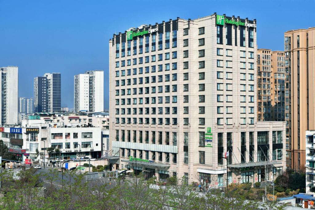 un edificio alto en medio de una ciudad en Holiday Inn Express Chengdu Huanhuaxi, an IHG Hotel, en Chengdú