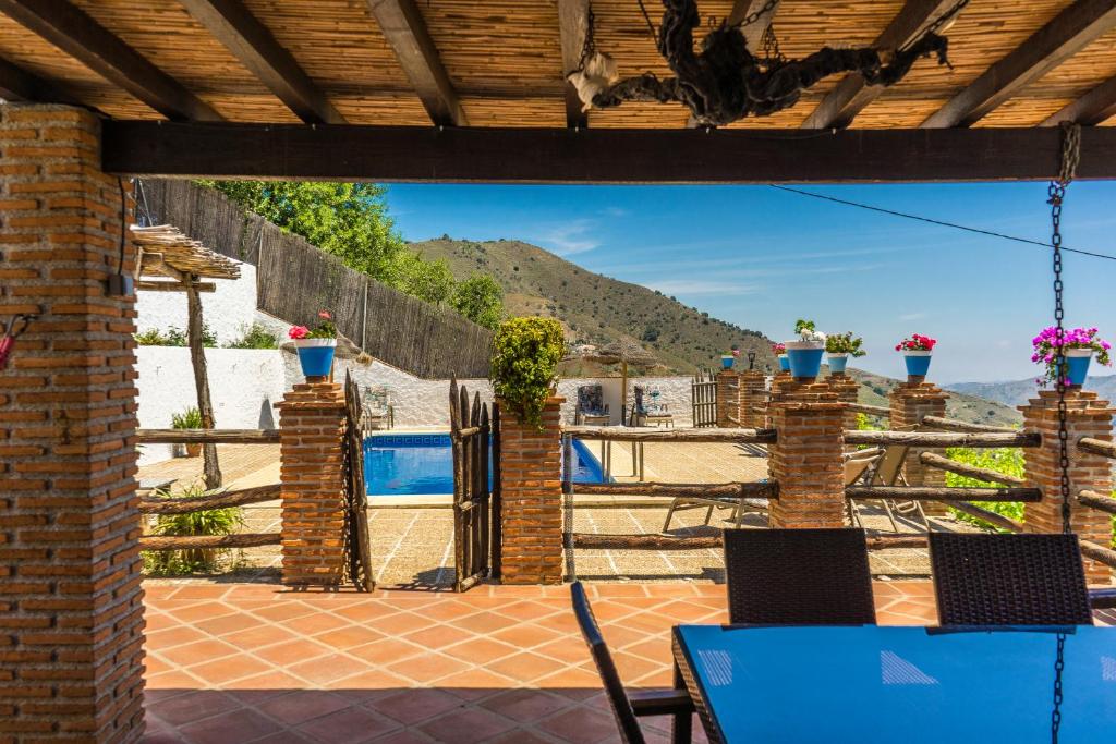 Elle offre une vue sur une terrasse avec une table et des chaises. dans l'établissement Malaga mountains winehouse with private pool, à Borge