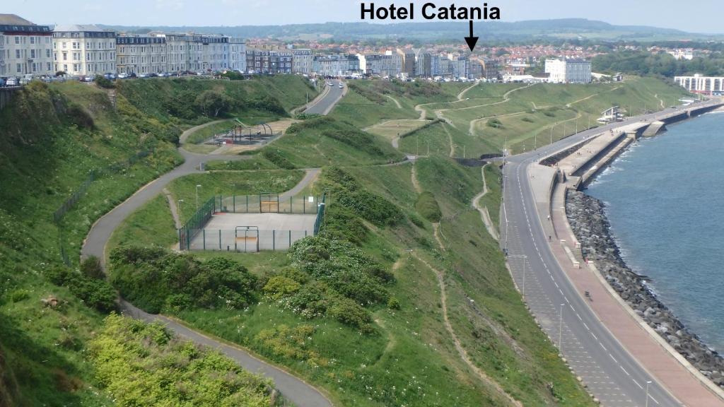 an aerial view of a building on a hill next to the ocean at Hotel Catania in Scarborough