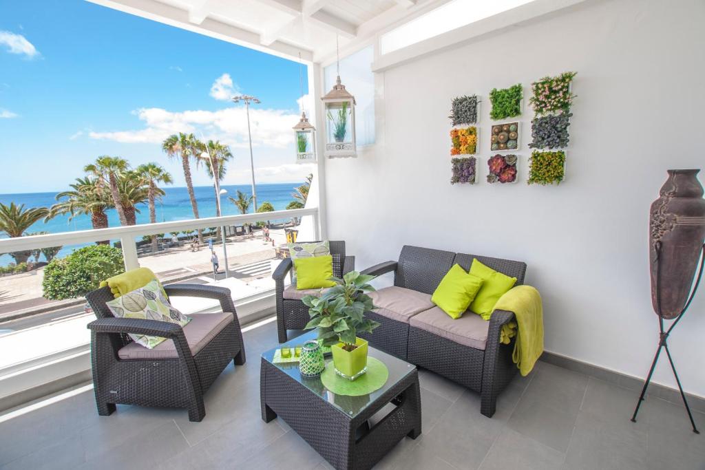 a living room with a couch and chairs and a balcony at Casa Oceano on the front line with amazing sea views in Puerto del Carmen