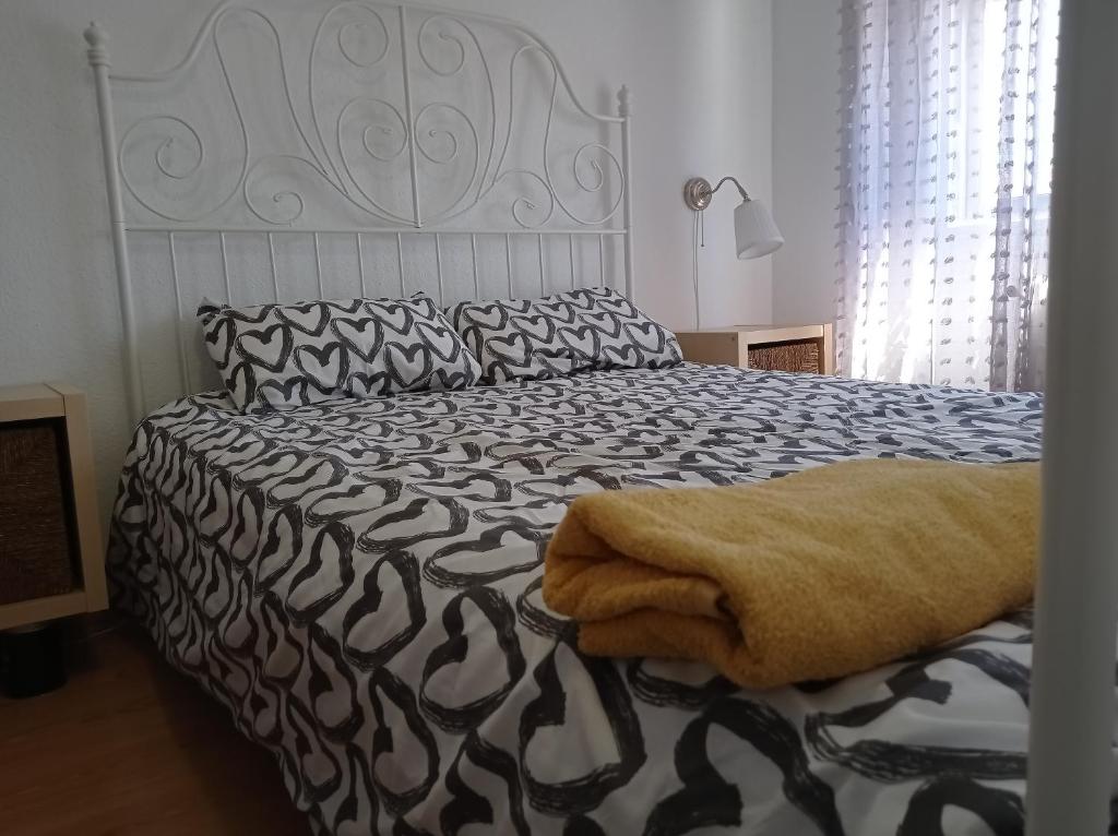 - une chambre avec un lit et une couette noire et blanche dans l'établissement Apartamento TISARE wifi, à Valladolid