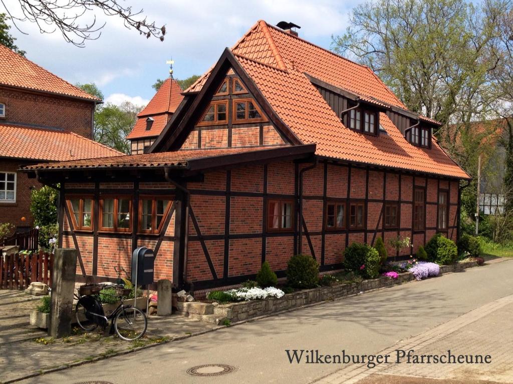 Casa aberrada com um telhado laranja numa rua em Wilkenburger Pfarrscheune Hannover Hemmingen em Hemmingen