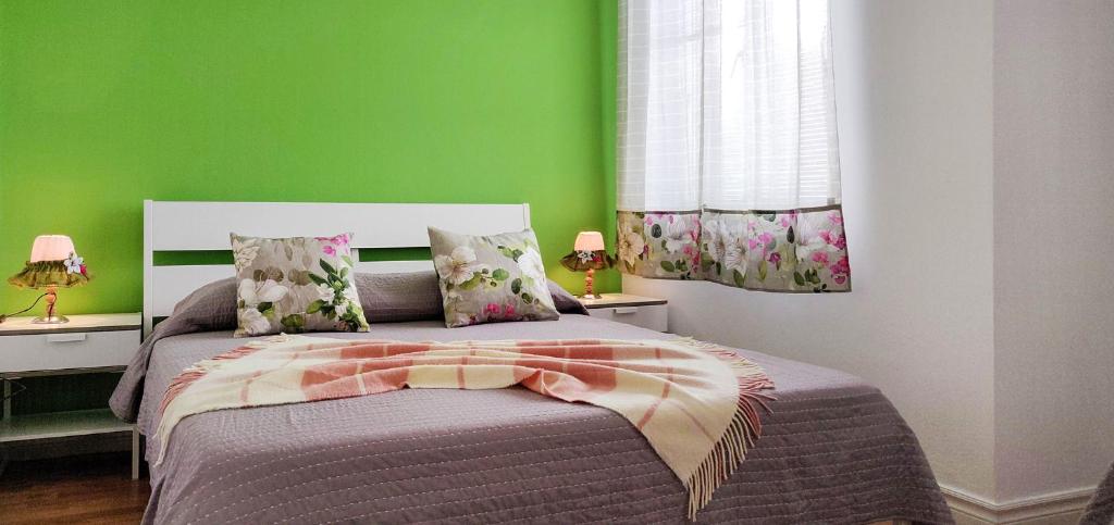 1 dormitorio con 1 cama con pared verde en Rainbow Guest House, en Madalena