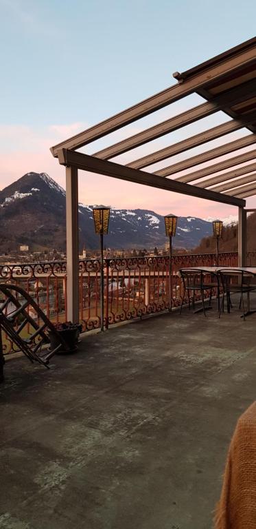 a patio with picnic tables with mountains in the background at Gasthof Schoenegg B&B in Goldswil