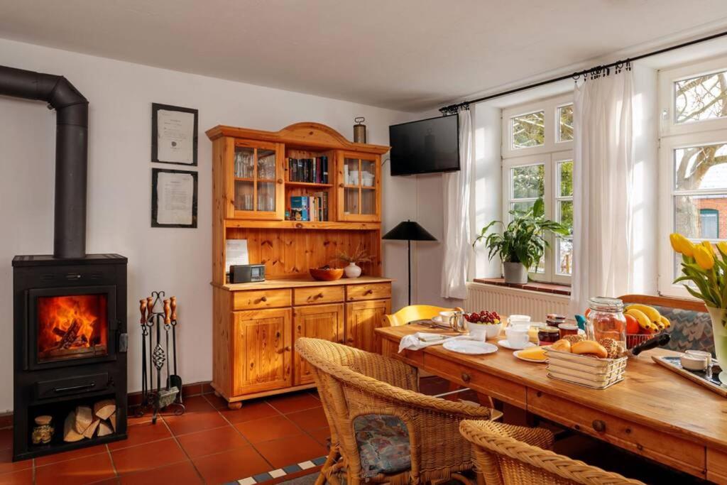 cocina con mesa de madera y estufa de leña en Ferienwohnung Familienzeit mit Sauna en Hohen Pritz