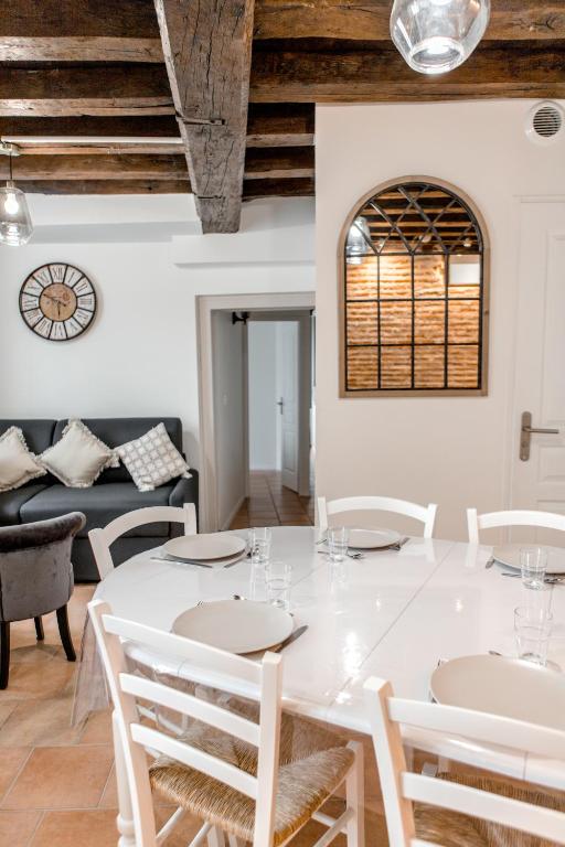 une salle à manger avec une table et des chaises blanches dans l'établissement Au Bourg Neuf, à Orléans