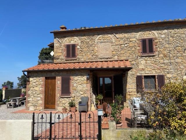 una casa de piedra con una valla delante de ella en Podere Doccia di Sopra, en Volterra