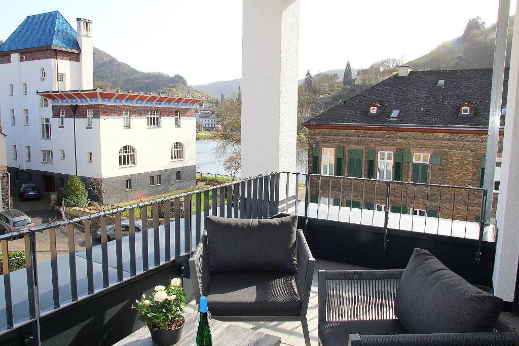 - un balcon avec 2 chaises et une bouteille de vin dans l'établissement Mosel-Loggia - Luxusapartment -Terrass - Klimaanlage, à Traben-Trarbach