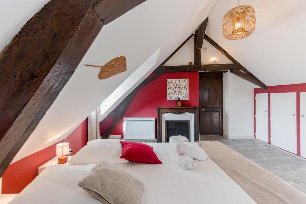 sypialnia z dużym białym łóżkiem z czerwoną ścianą w obiekcie Au Bourg Neuf w Orleanie