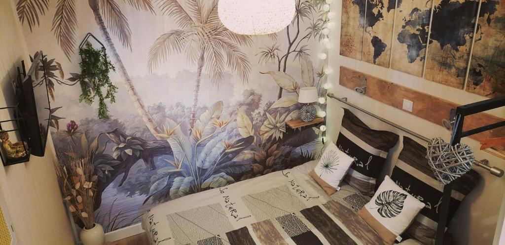 a bedroom with a tropical mural on the wall at Studio Confort Netflix Business in Brétigny-sur-Orge