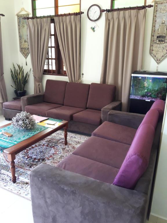 Anjung Nor Muslim Homestay في دونجون: غرفة معيشة مع أريكة وطاولة قهوة