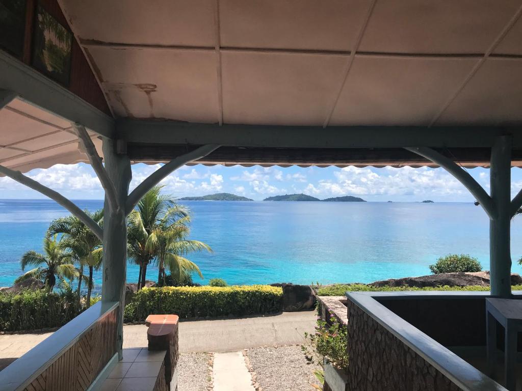 - une vue sur l'océan depuis la terrasse couverte d'une maison dans l'établissement Hotel L'Ocean, à La Digue