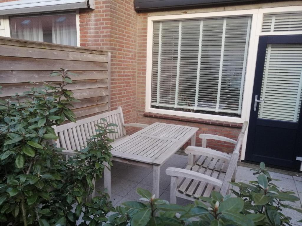 einen Picknicktisch und zwei Stühle auf einer Terrasse in der Unterkunft Woning Emmastraat in Katwijk aan Zee