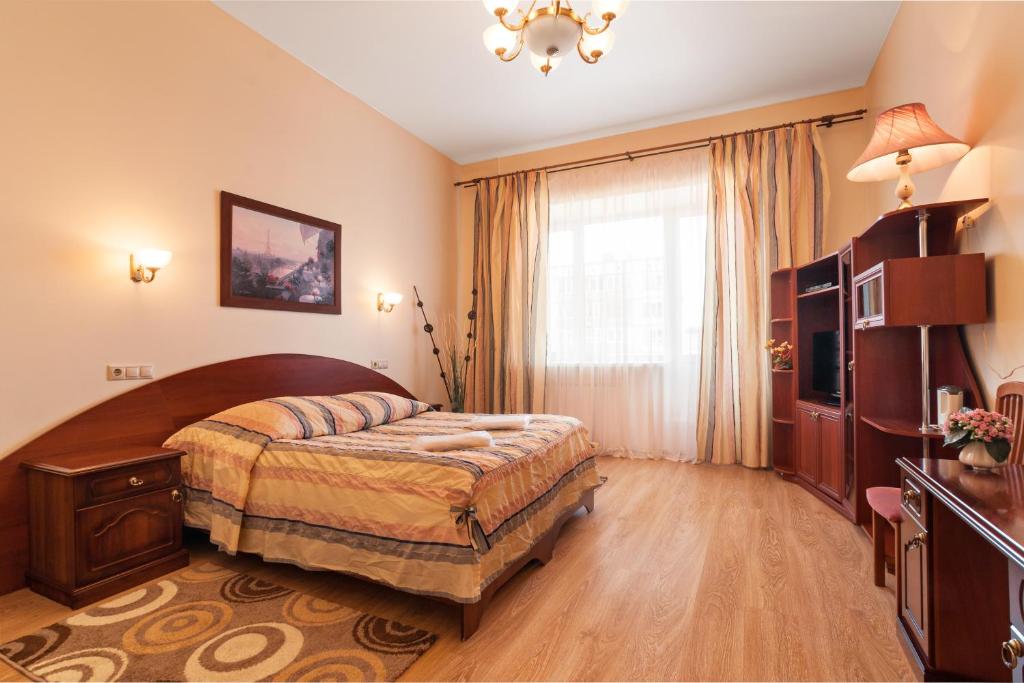 a bedroom with a large bed and a television at Petrovskaya Hotel in Shlisselburg