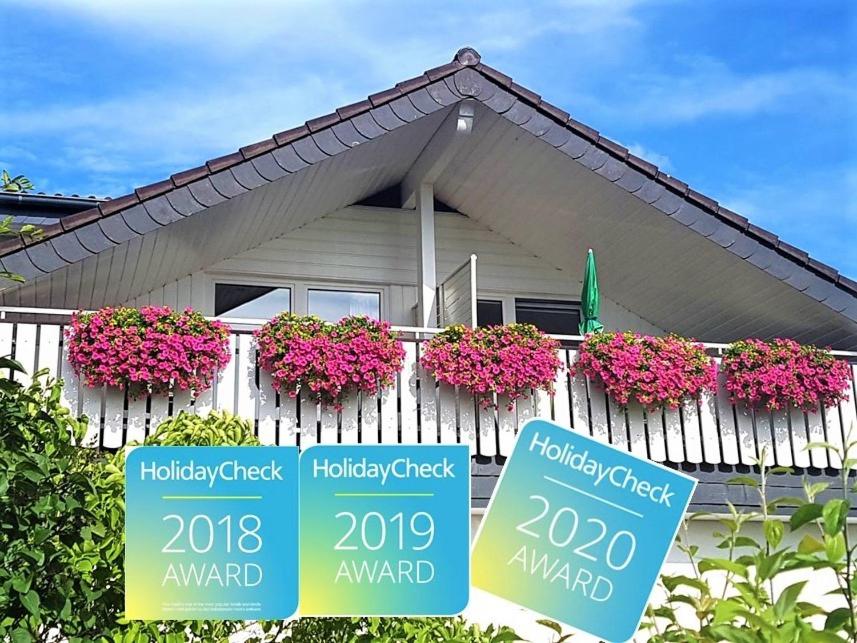 a house with flower boxes on a fence at Gästehaus Sonnenhügel in Möhnesee