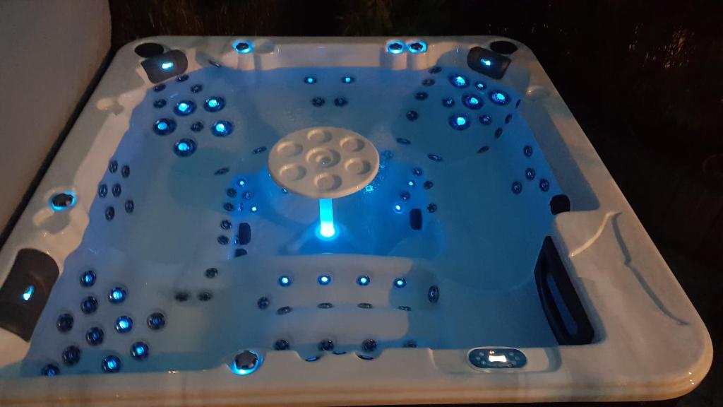 a bath tub filled with water with blue lights at La Villa Esterel &amp; SPA in Village-Neuf