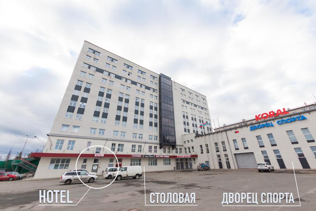ペトロザヴォーツクにあるГостиница Koralの駐車場に車を停めた大きな白いホテル