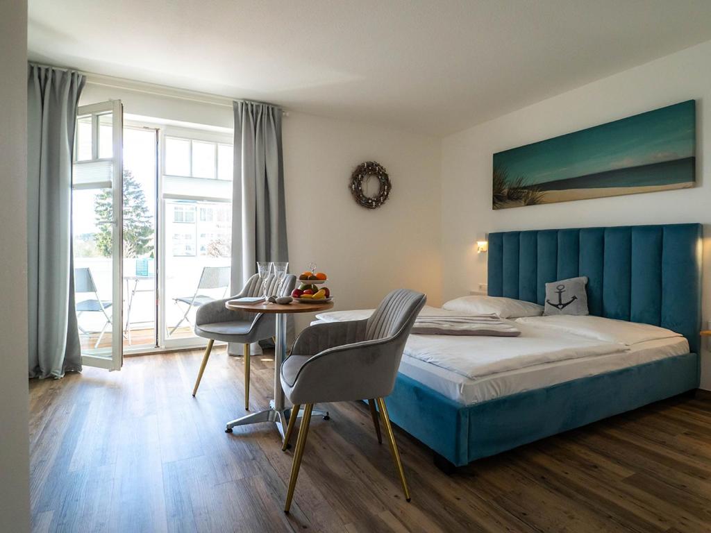 a bedroom with a bed and a table with chairs at Hotel meerblau in Ostseebad Sellin