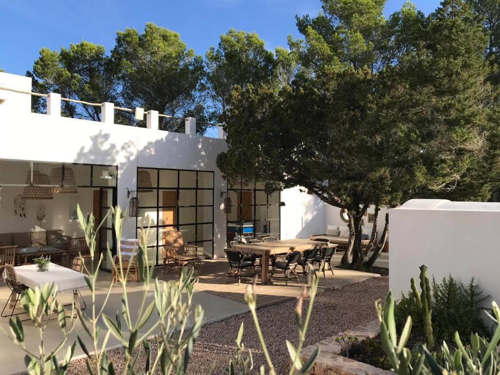 a white house with a table and chairs at Feliz Lagartija in Cala Saona
