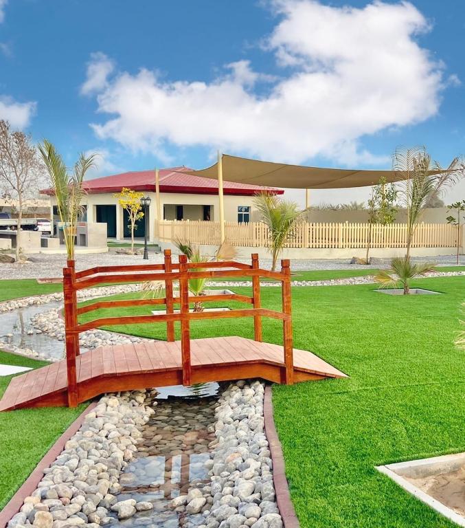 a wooden bench in a park with a building at Seven Elements Resort in Ras al Khaimah