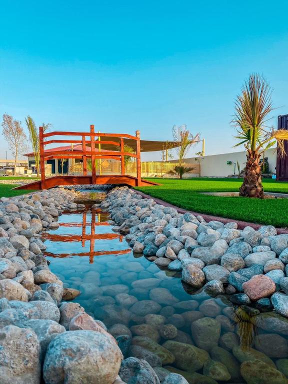 a bridge over a stream with rocks and a pond sidx sidx sidx at Seven Elements Resort in Ras al Khaimah