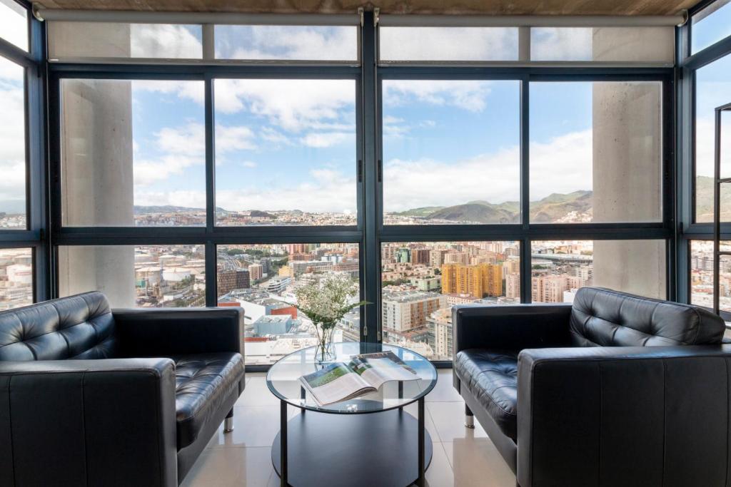 sala de estar con 2 sofás y mesa de cristal en HomeForGuest NEW Modern Penthouse Apartment with panoramic views of Santa Cruz, en Santa Cruz de Tenerife