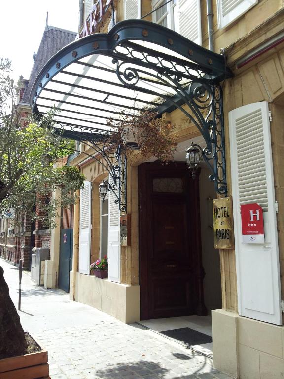 a building with awning over a door on a street at Hôtel De Paris in Charleville-Mézières