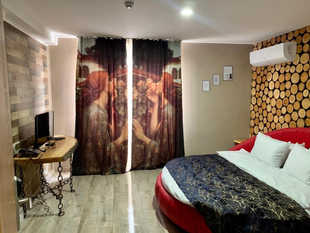 a bedroom with a bed and a desk and a curtain at Grand Altunhan Hotel in Svilengrad