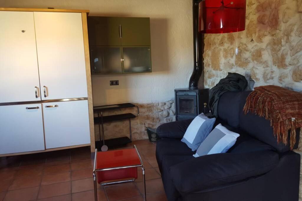 Il comprend un salon avec un canapé bleu et une cuisine. dans l'établissement Casa Ambiente Rural: En plena Ribera del Duero, à Mélida