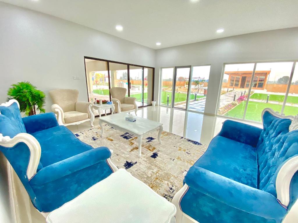 a living room with blue chairs and a table at Seven Elements Resort in Ras al Khaimah